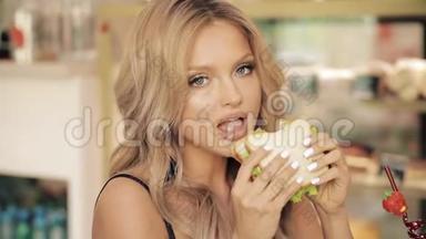 可爱的<strong>饥饿</strong>的女人吃着美味的三明治享受食物